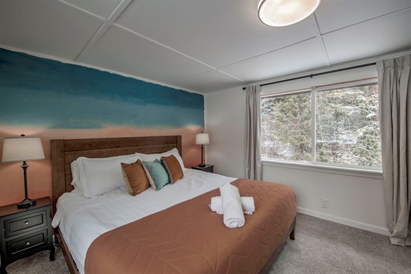 Wake up to peaceful forest views and the sounds of Spruce Creek — your cozy bedroom features soft bedding, warm tones, and a tranquil space that feels yours perfectly. 