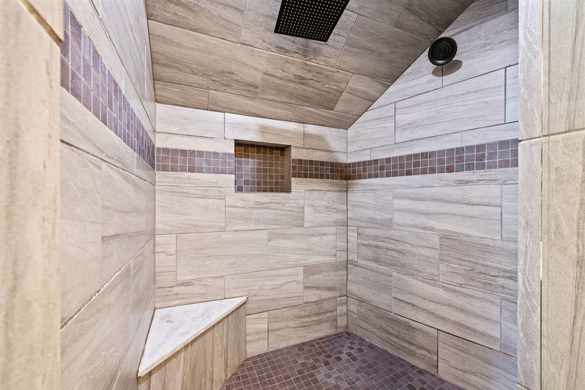 The large walk-in shower features sleek tile work and a spacious layout, offering a refreshing and comfortable place to start or end your day.
