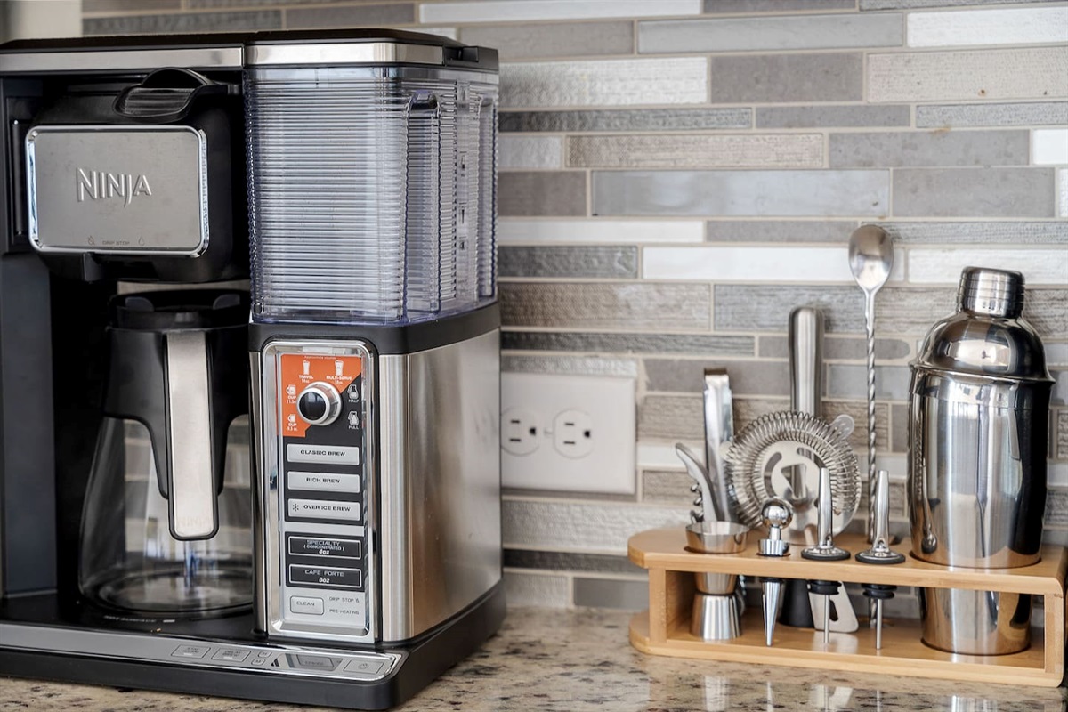 Welcome to a stylish kitchen setup with a modern Ninja coffee maker and a complete cocktail tool set.