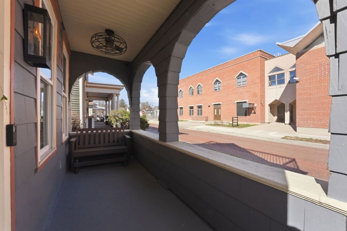 Covered front porch with seating, offering a charming spot to relax and enjoy the neighborhood views
