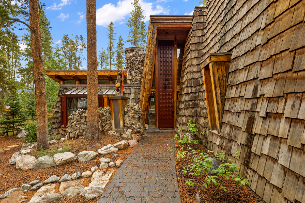 Summer exterior with rustic landscaping and imposing front entrance