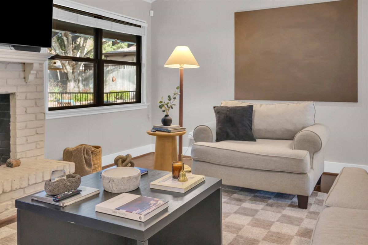 Elegant living room sitting area accented with curated artwork, offering a stylish and inviting space to relax.