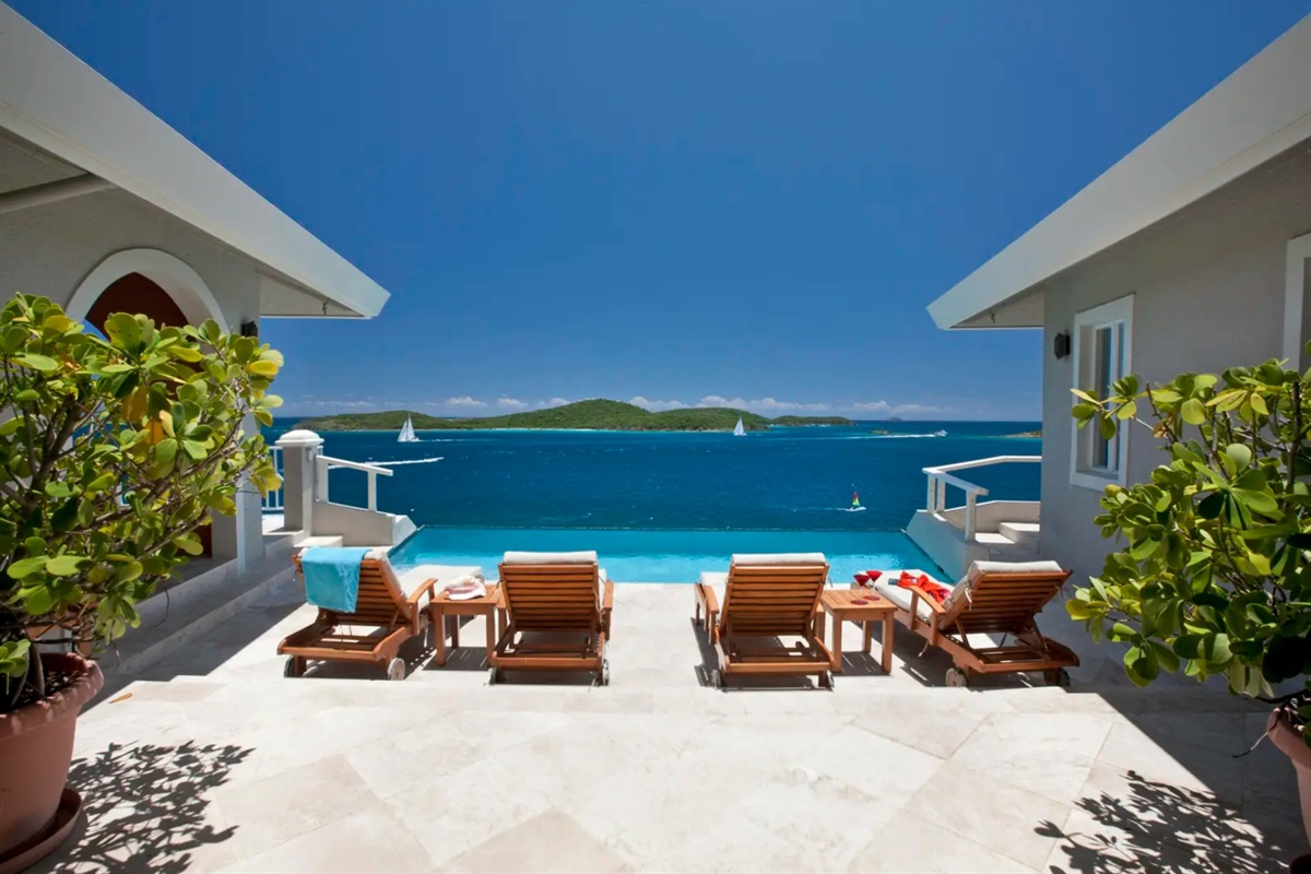 Views of the pool against a backdrop of Caribbean turquoise and blue water.