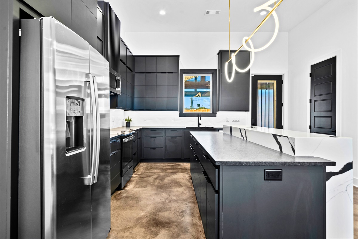 A beautifully designed kitchen with crisp lines, top-of-the-line appliances, and plenty of counter space, offering both functionality and aesthetic appeal.