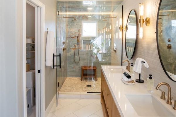 Refresh together in the custom two-person shower, featuring dual shower heads for a spacious, luxurious, and personalized experience.