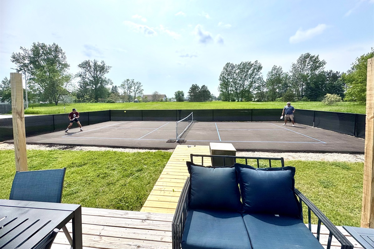 Spacious deck overlooking the pickleball court, perfect for al fresco dining and socializing. Enjoy the view while grilling on one of the two provided BBQs.