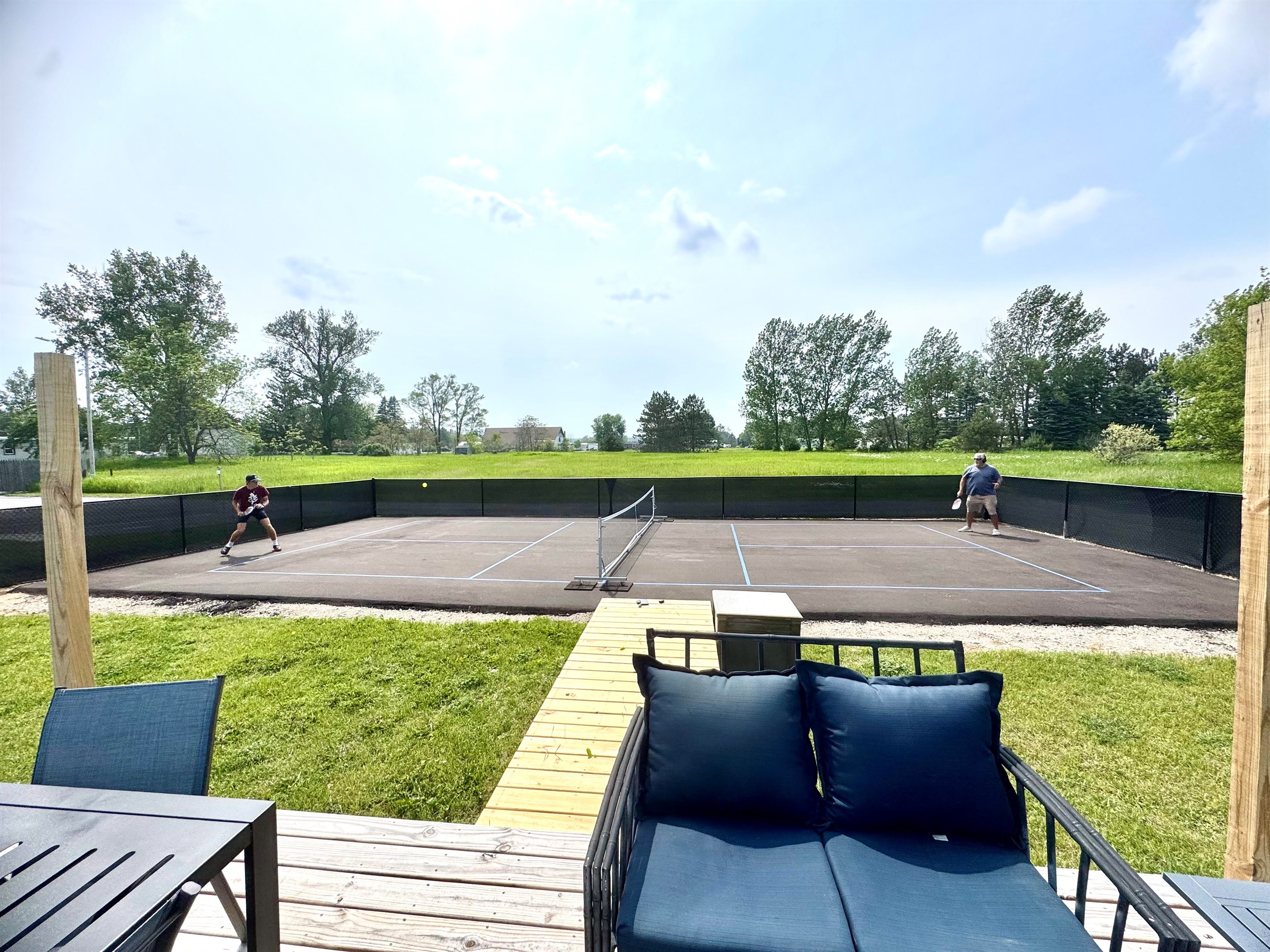 Spacious deck overlooking the pickleball court, perfect for al fresco dining and socializing. Enjoy the view while grilling on one of the two provided BBQs.
