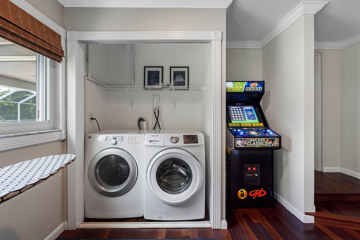 Convenient laundry nook with washer, dryer, and overhead shelving for storage.