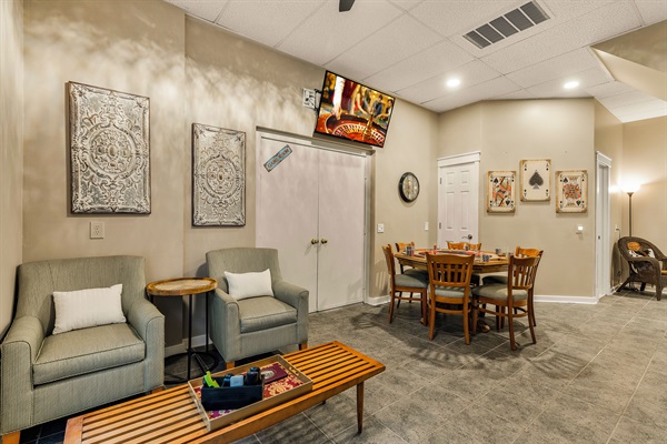 Lounge area with card table and TV with Xbox Series S
