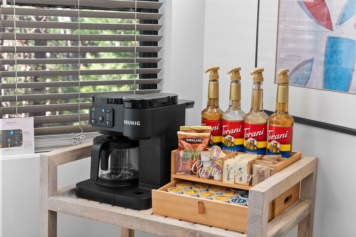 Coffee bar stocked with Torani syrups, organic K-cups, ground coffee, sugar and cream