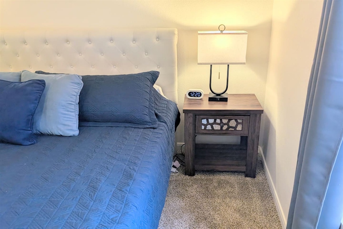 Bedside tables have storage, an alarm clock, and easy access to charging ports.