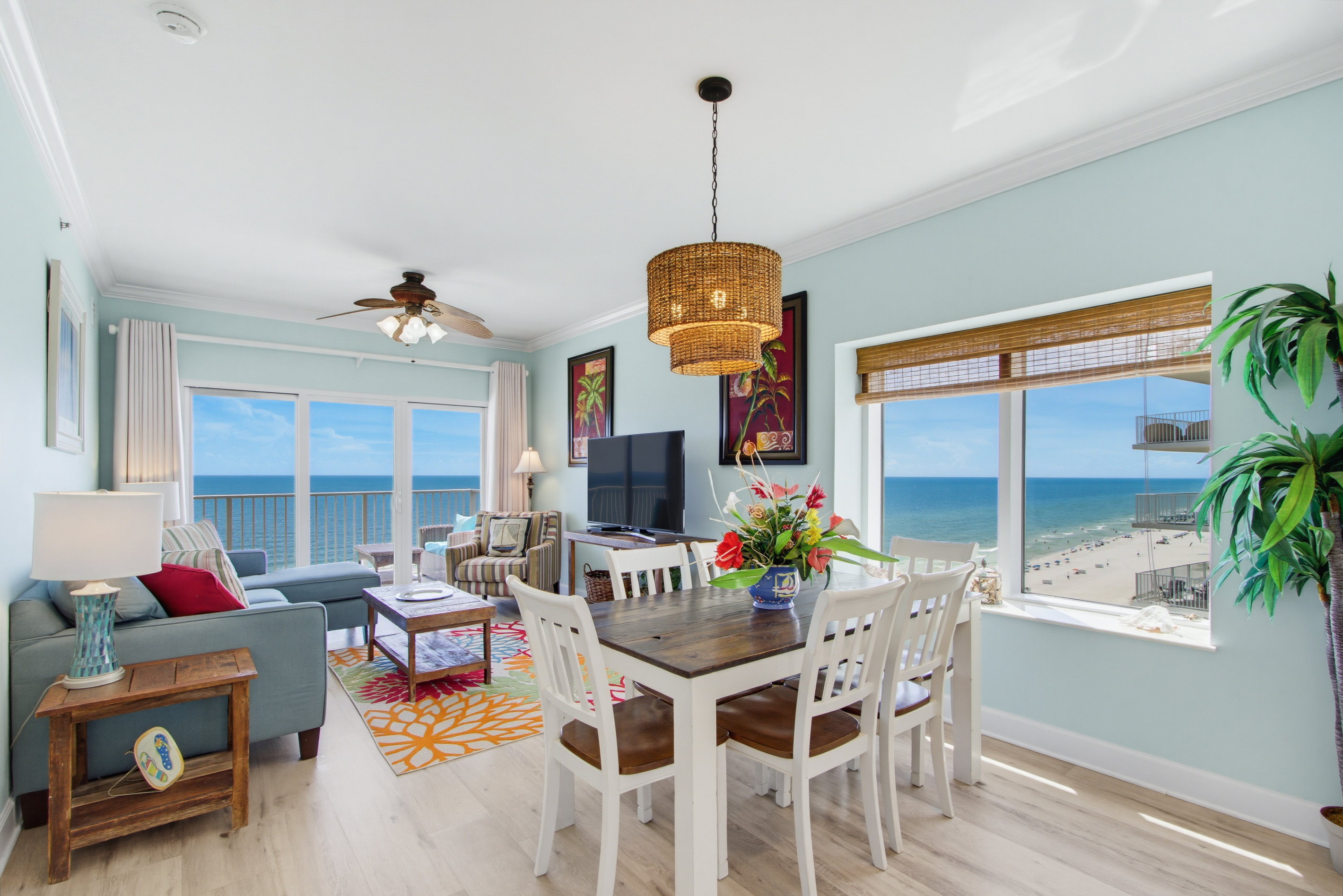 Open living and dining area with panoramic Gulf views and a TV.