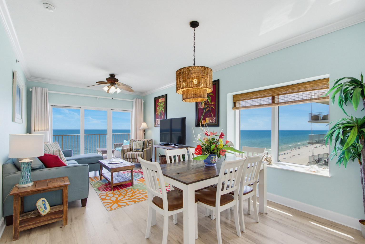 Open living and dining area with panoramic Gulf views and a TV.