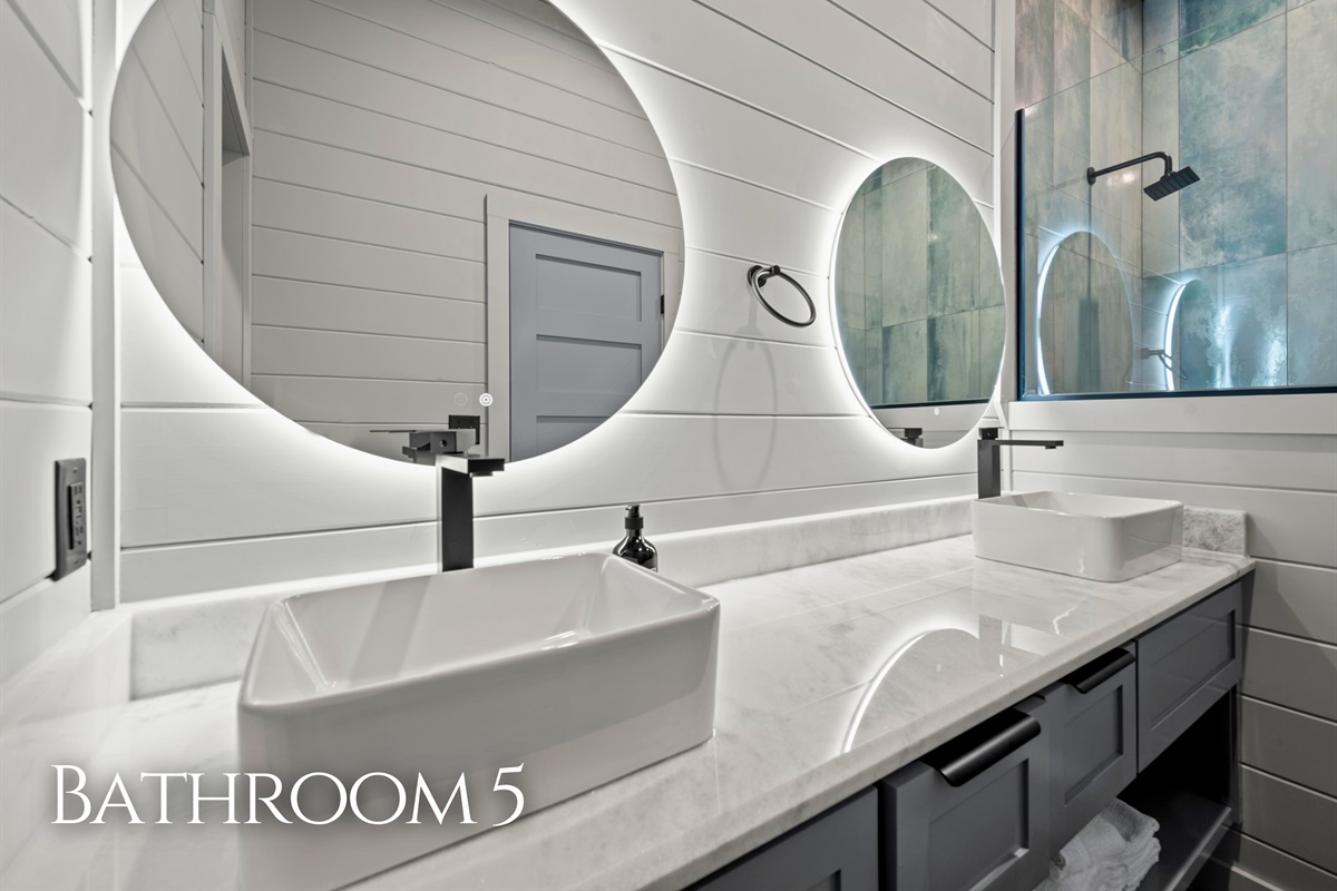 Modern lighting and a wide vanity offer plenty of space to get ready while adding a stylish touch to the bathroom.