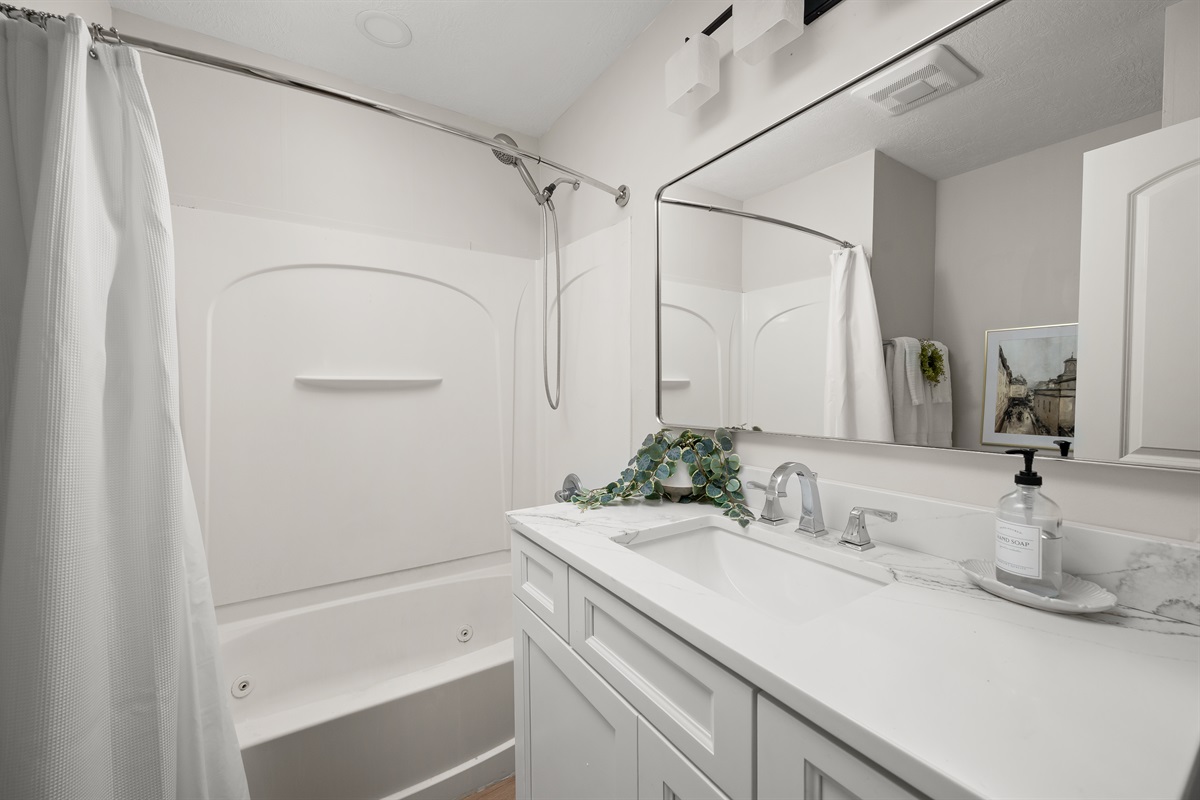 Full bathroom with a shower and tub combo, toilet, sink, and plenty of counter space to comfortably get ready for the day.