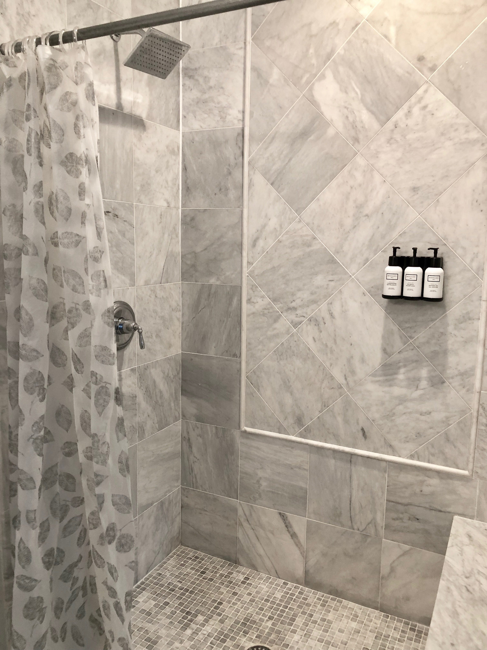 The ensuite bath features a sleek walk-in shower, marble tile, and spa-style fixtures—your own private escape just steps from the bed.