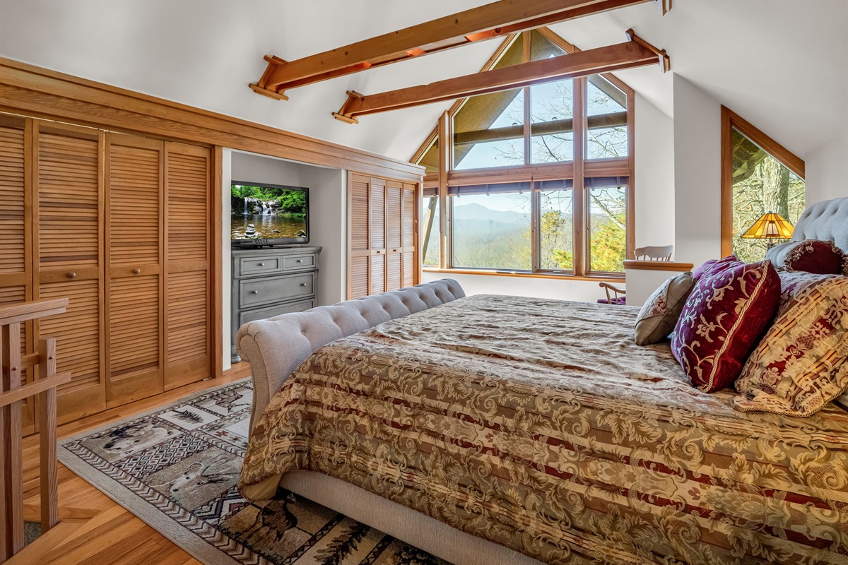 Upstairs master bedroom with king bed, long range views, and private bathroom.