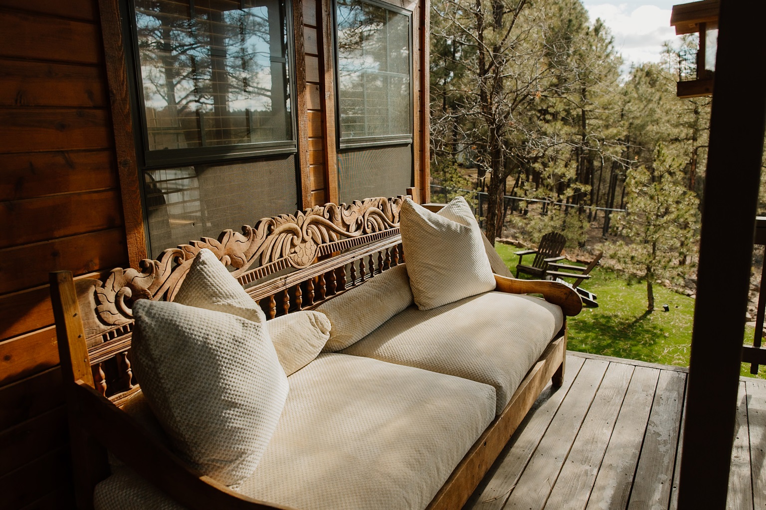 Step onto your private back patio where a plush daybed beckons beneath towering pines. Surrounded by sweeping mountain views and whispering forest, this secluded retreat offers the perfect sanctuary for afternoon naps and morning coffee.