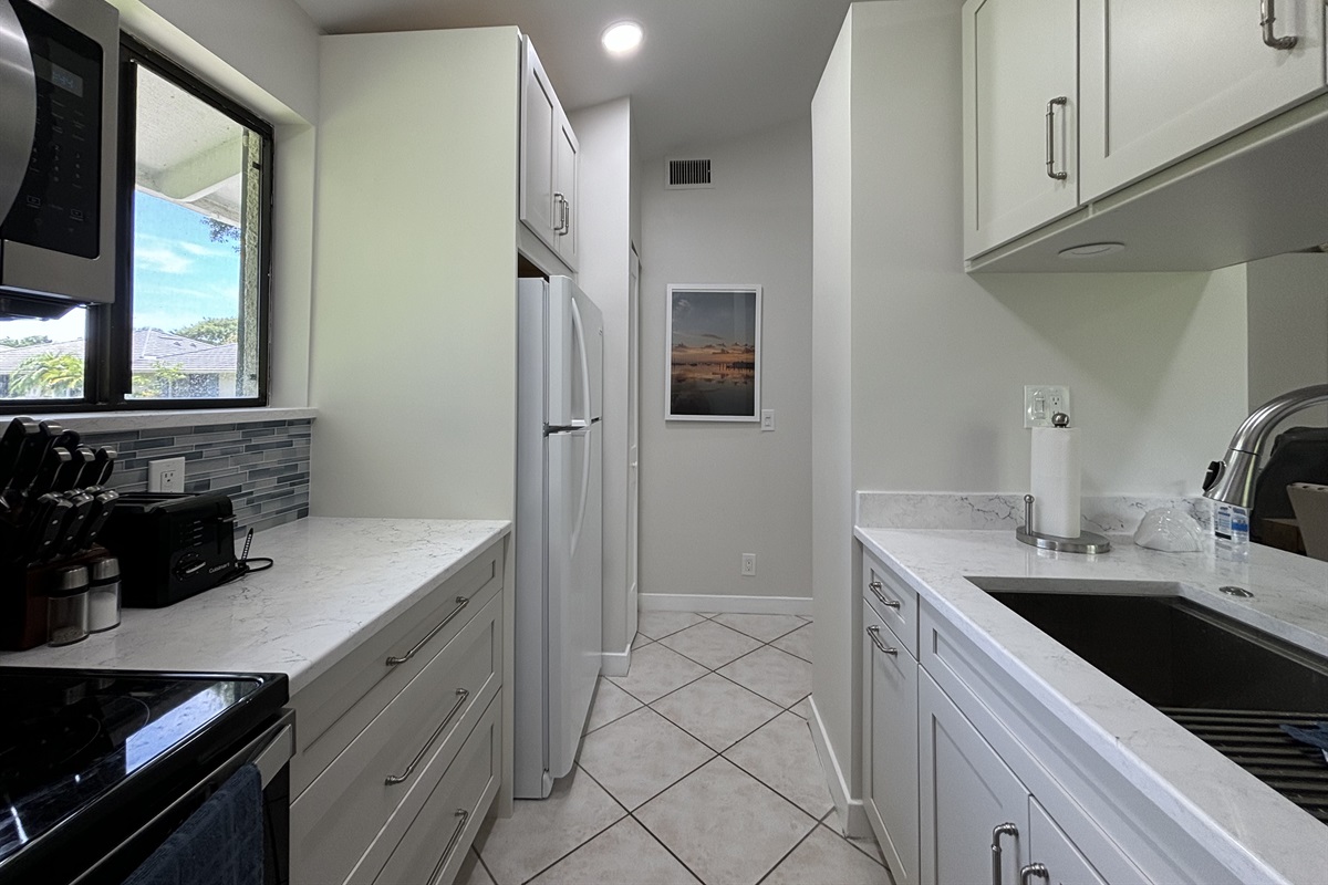The galley-style kitchen is well-equipped with all the essentials needed to make home-cooked meals together.
