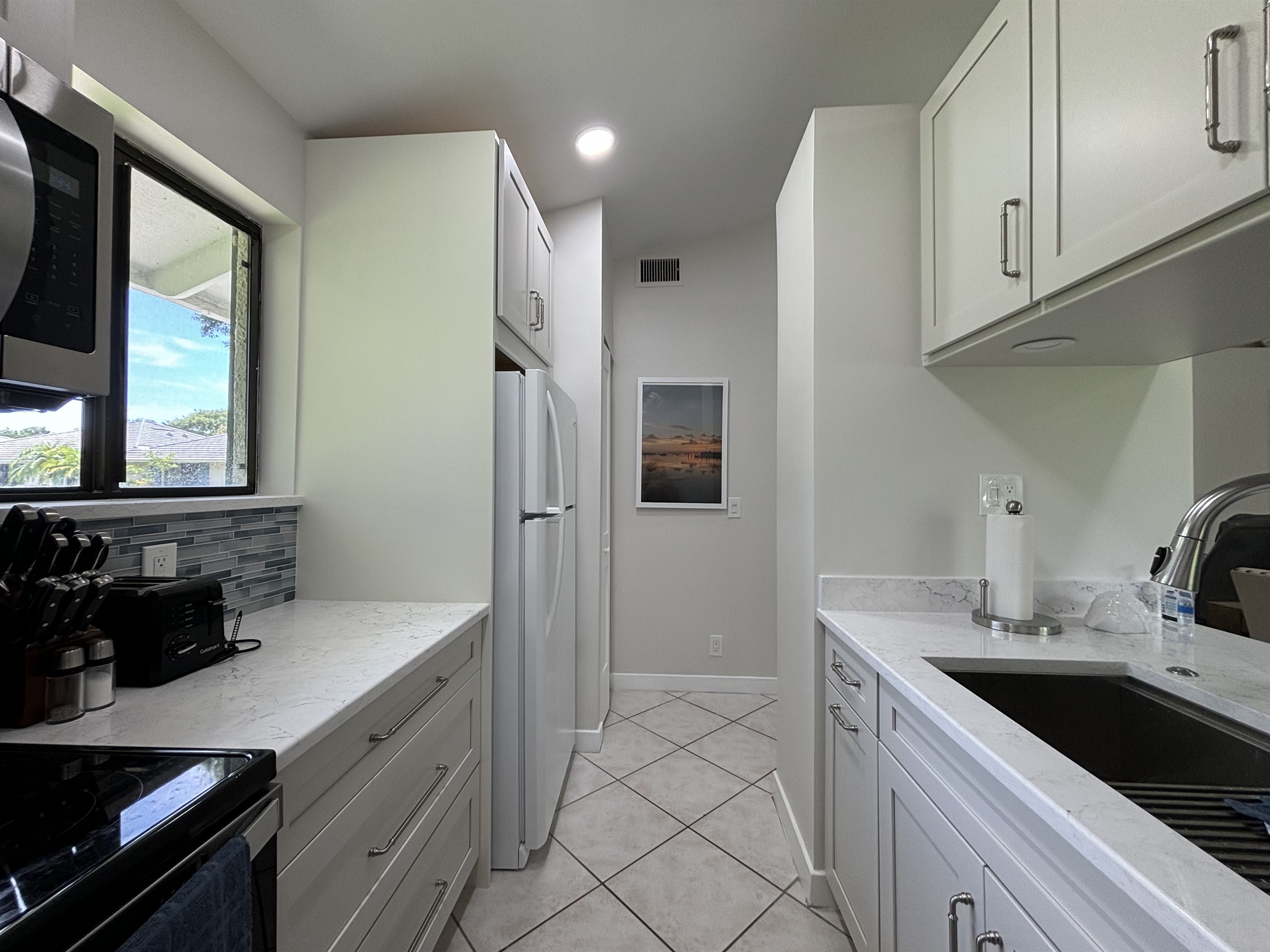 The galley-style kitchen is well-equipped with all the essentials needed to make home-cooked meals together.