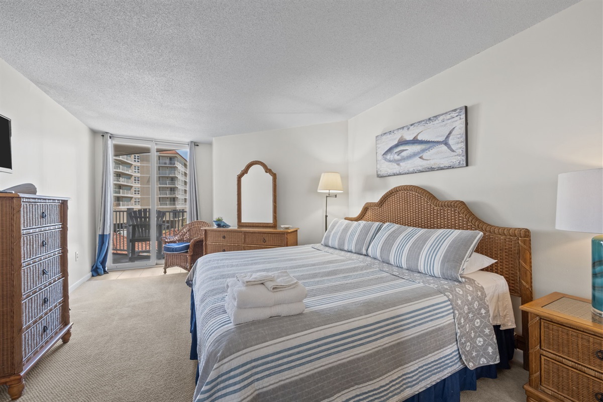 King bedroom retreat with private balcony access and soft coastal tones throughout