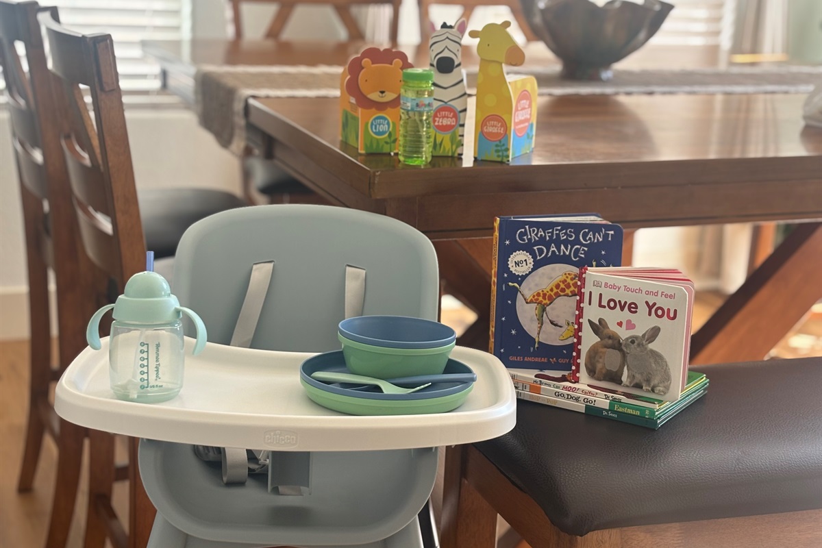 High chair provided along with an assortment of dinnerware and books.