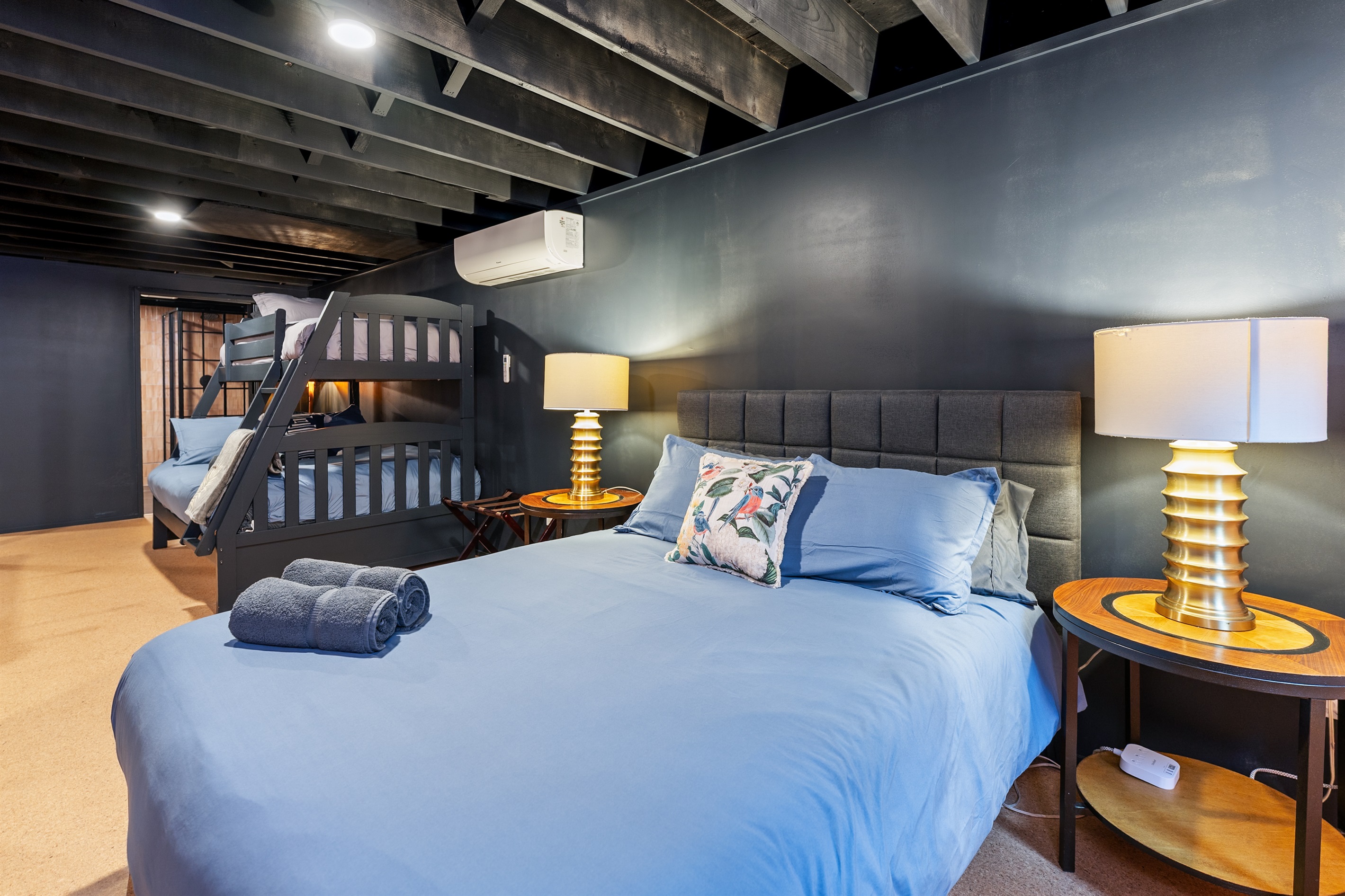 Comfortable lower-level bedroom with plush bedding and stylish lighting for a peaceful night’s sleep.