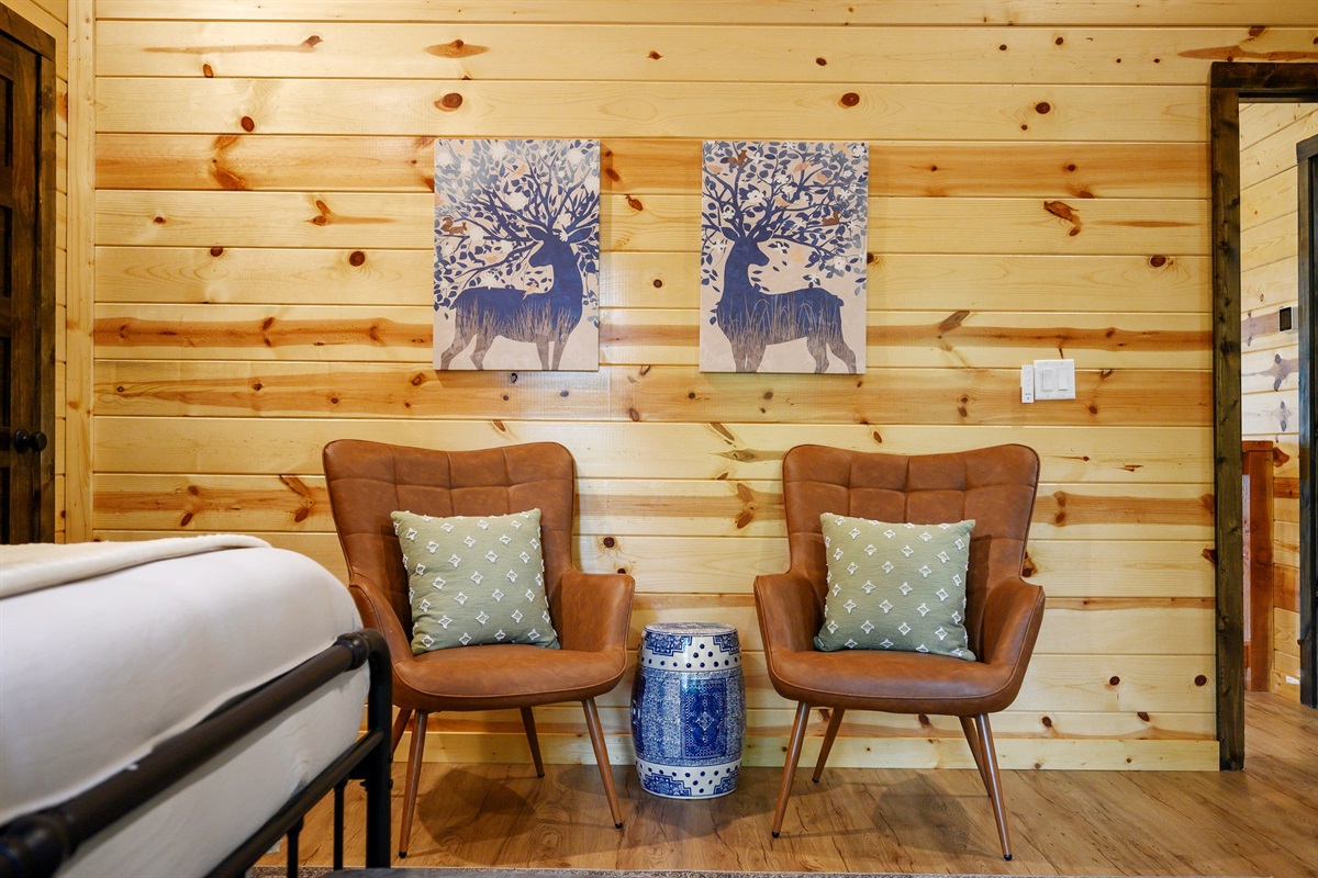 Two accent chairs and forest-themed art make the perfect retreat.