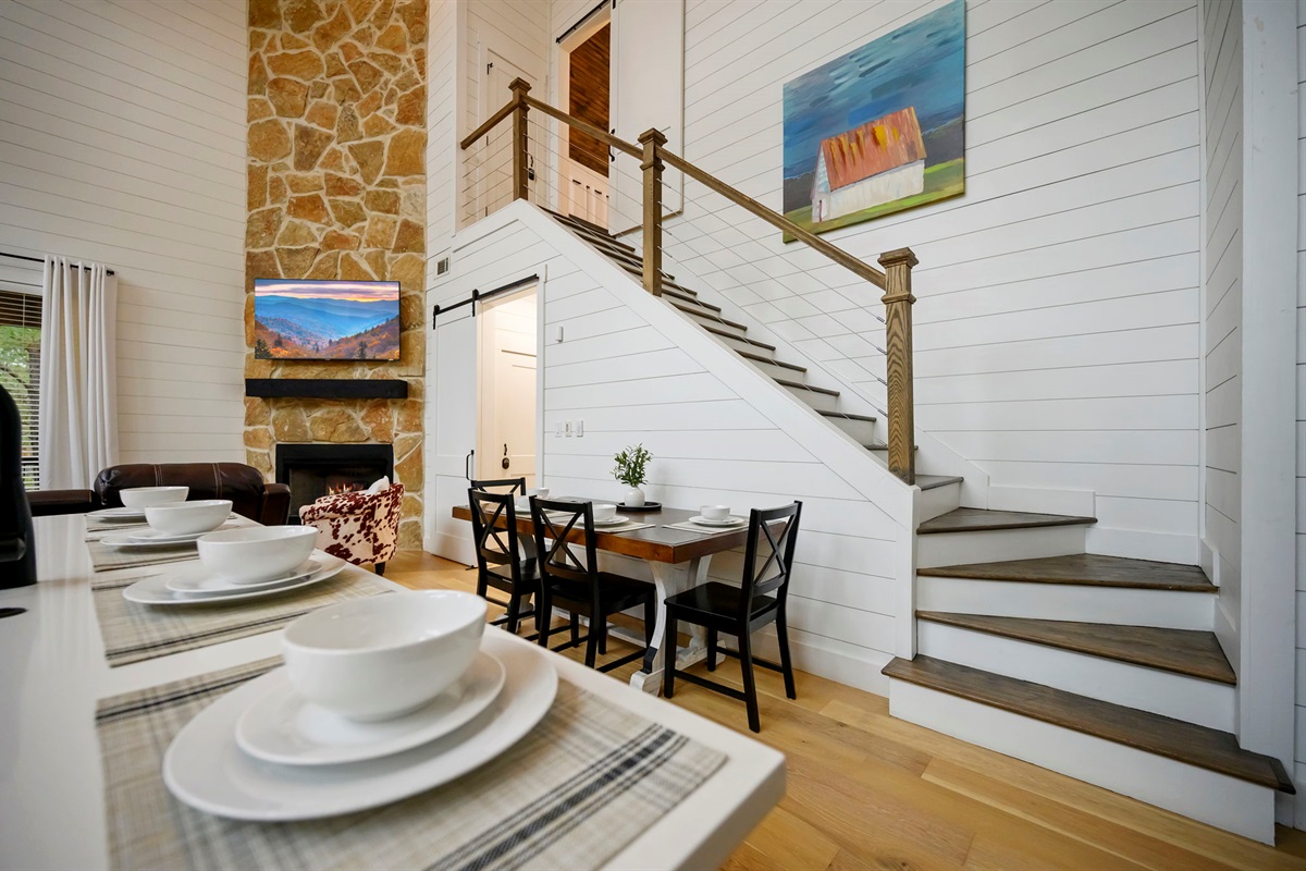 Dining space set beneath soaring ceilings, steps from the stone fireplace &mdash; perfect for gathering in style.