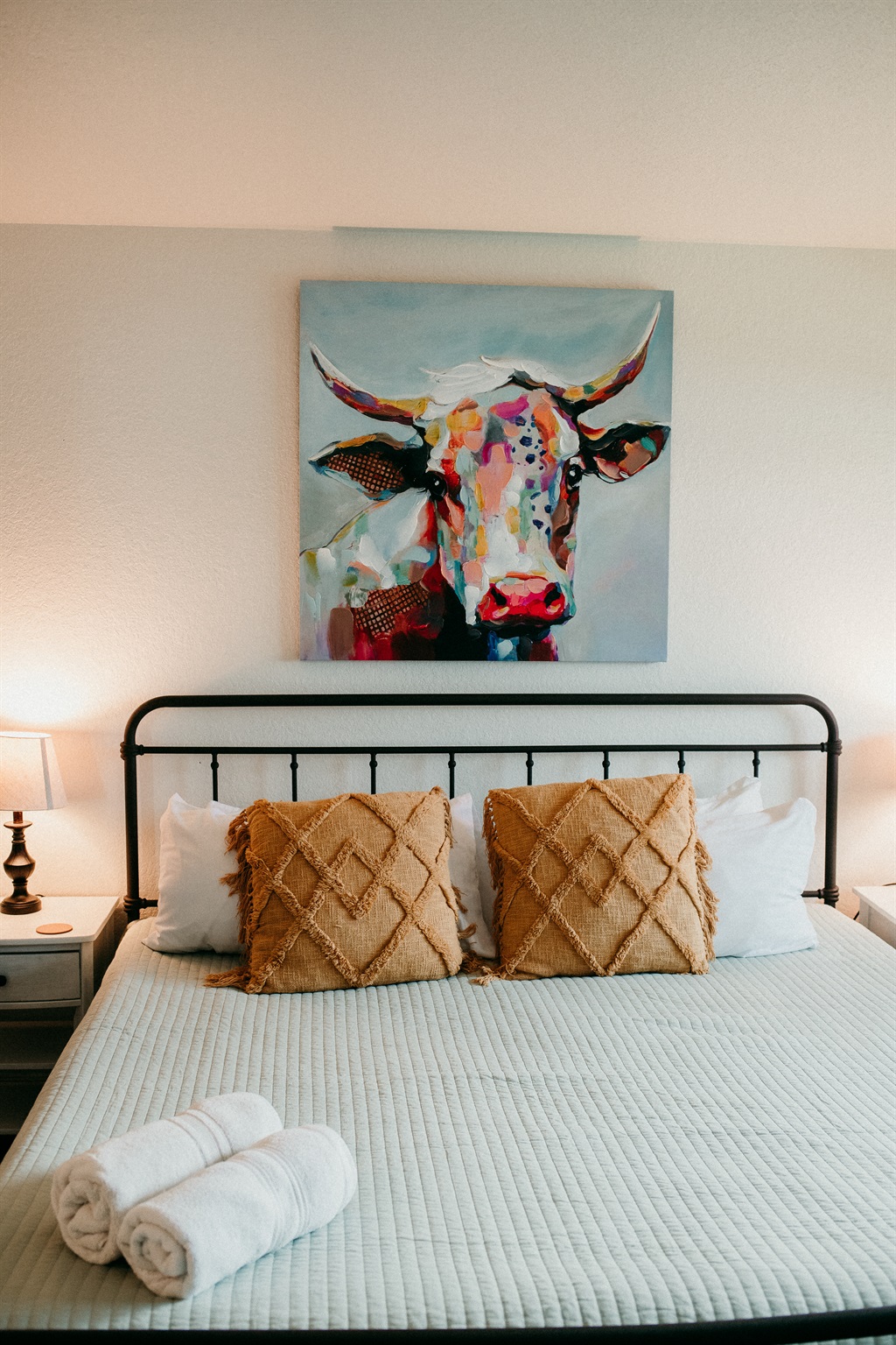 Relax in this cozy bedroom complete with plush linens and vibrant local art.
