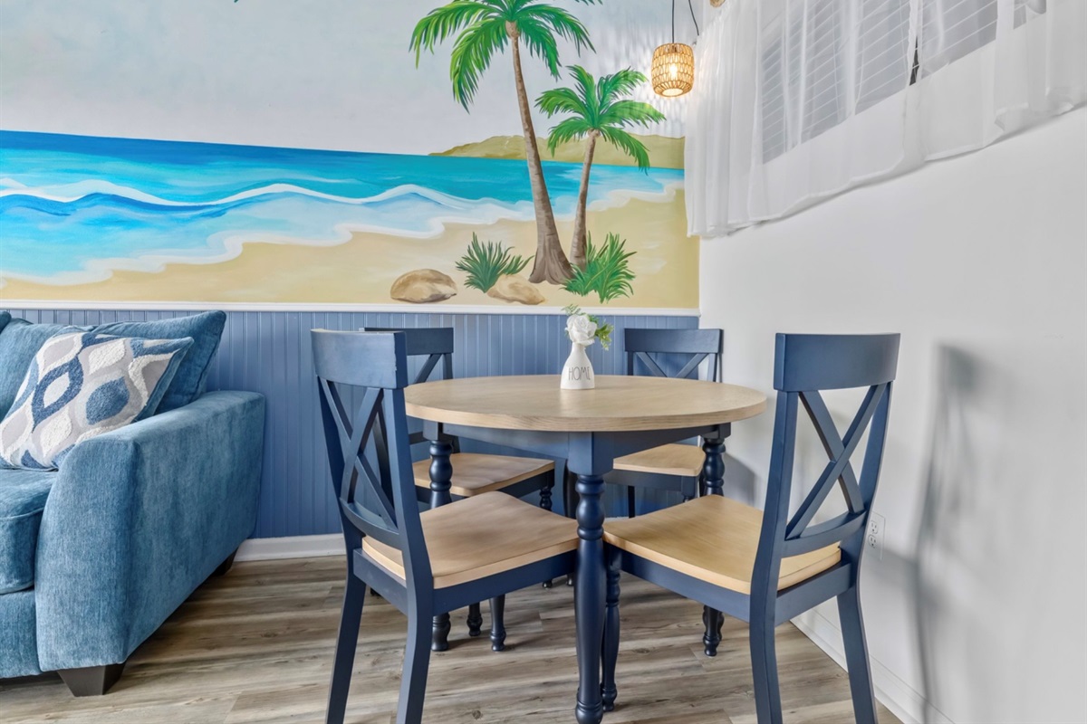 Gather, dine, reconnect 🍽️
A cozy dining space set against a hand-painted coastal mural. Perfect for morning coffee, takeout nights, or family meals after a sun-soaked beach day.