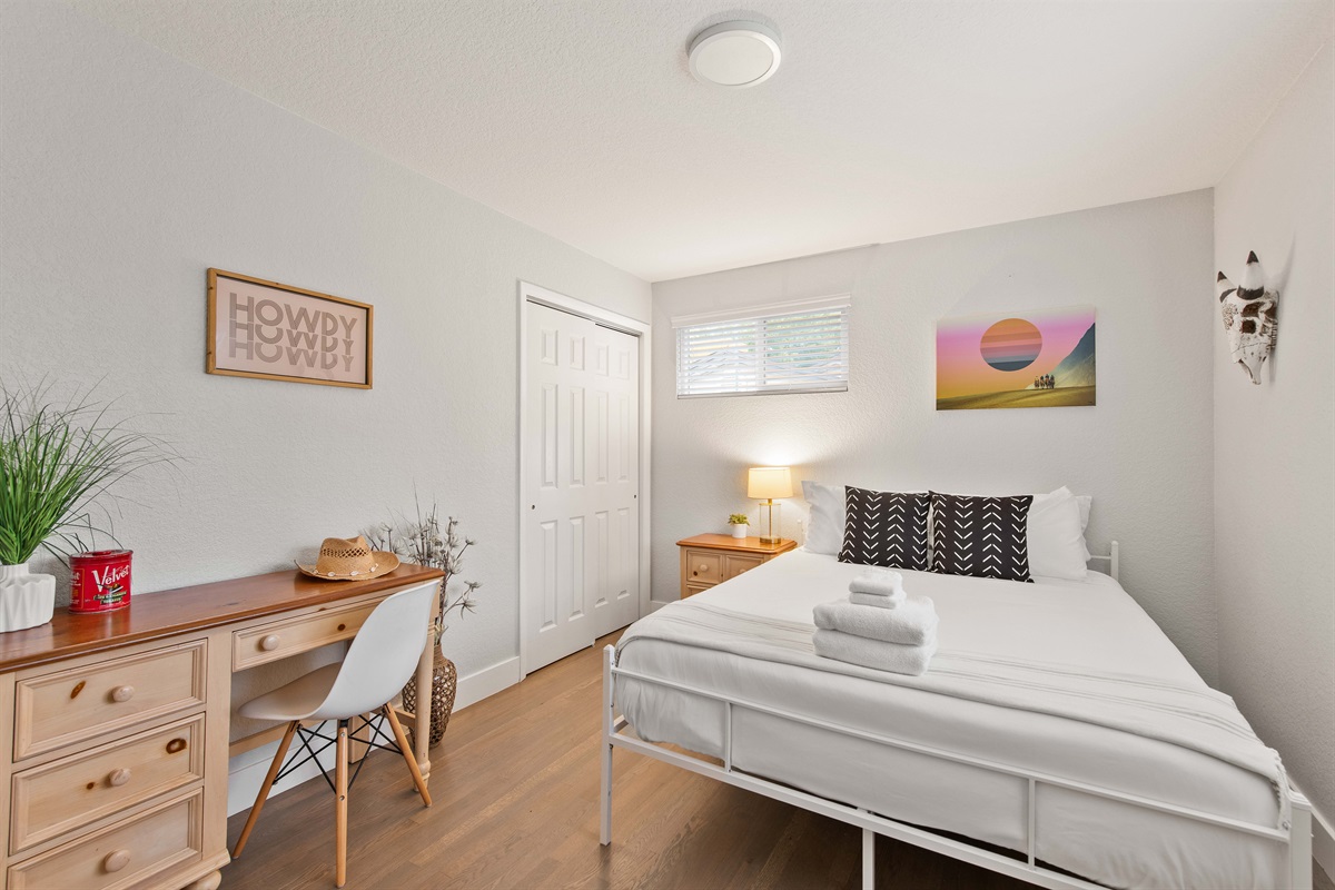 Comfortable queen bedroom with desk and fresh linens