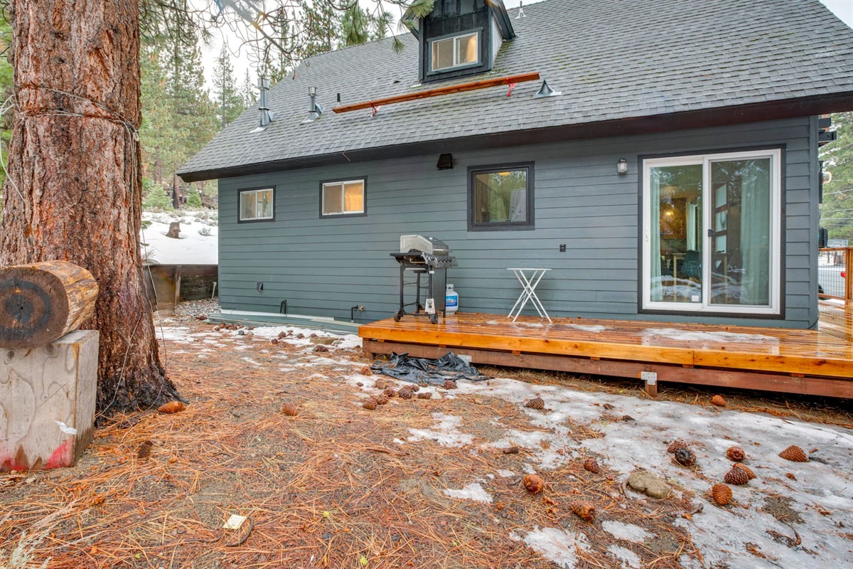 Side of house with BBQ grill on the deck.