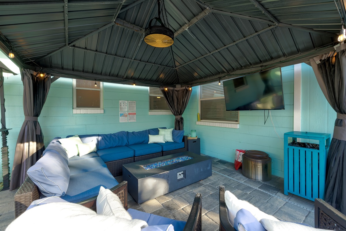 Covered outdoor lounge with fire table and TV