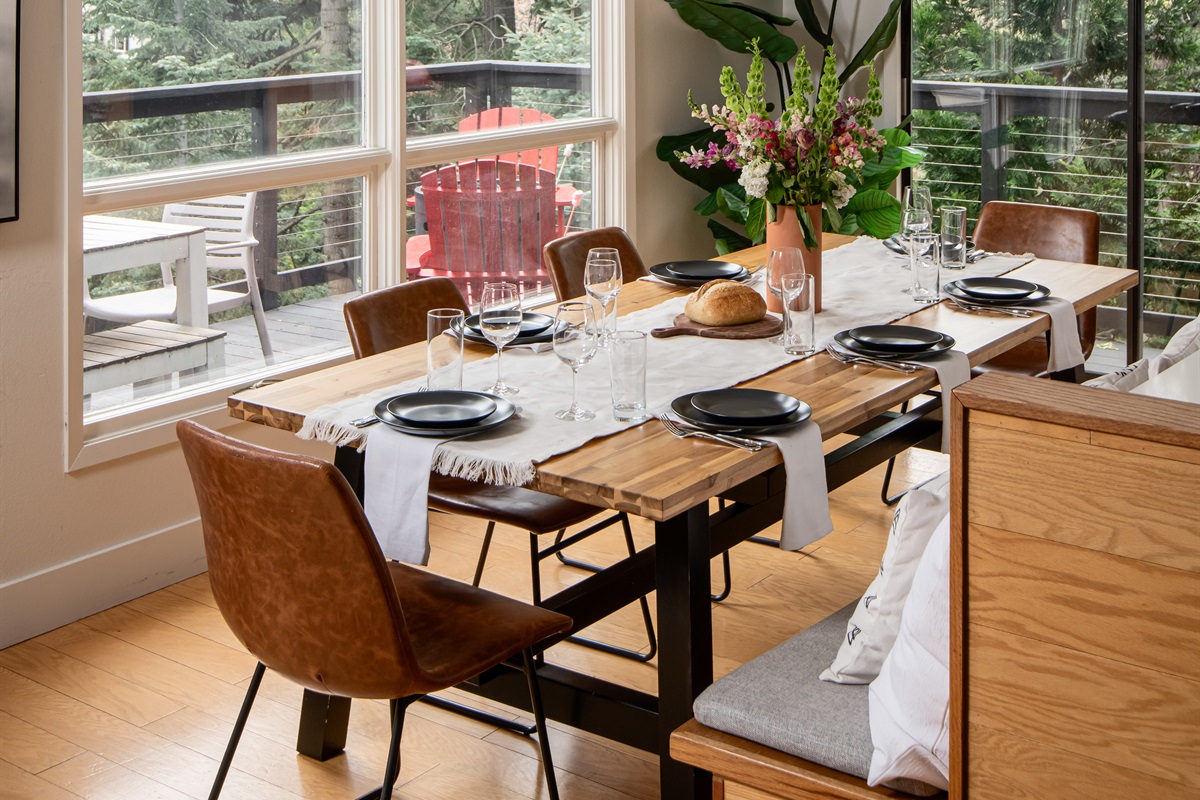Bright dining area with forest views and large windows—perfect for group meals, morning coffee, and enjoying a peaceful mountain getaway indoors.