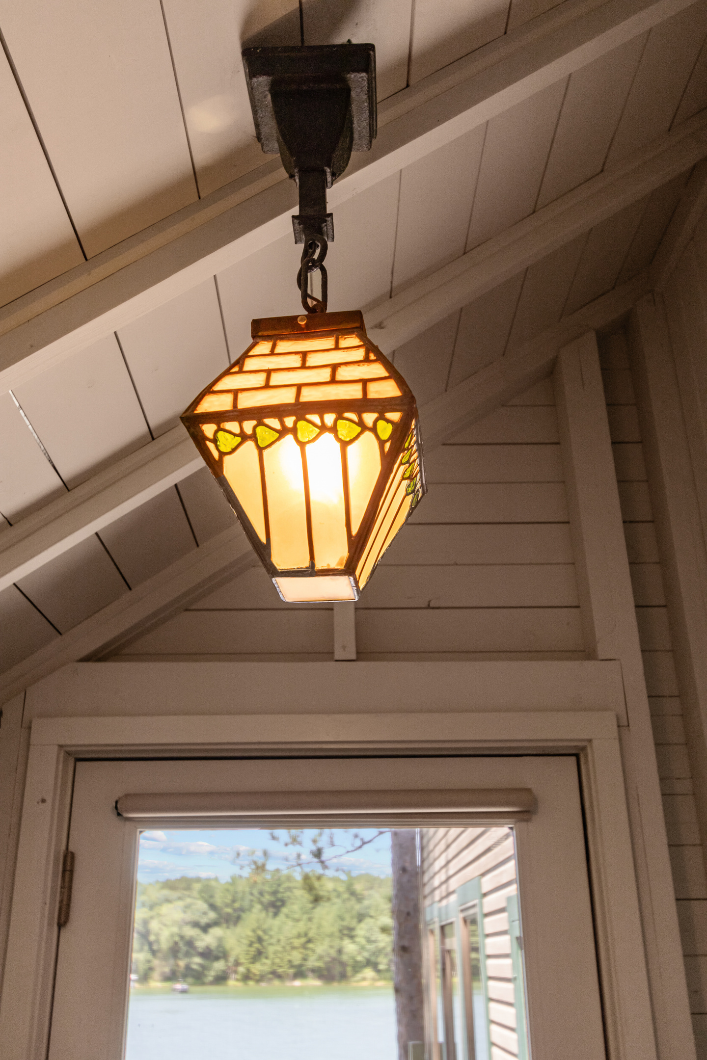 As you head upstairs, charming details like this beautiful stained-glass light add to the warm cottage character found throughout the home.