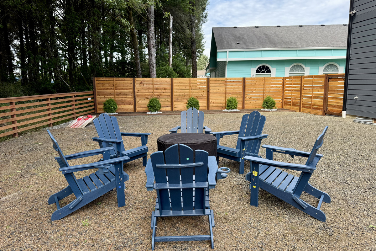 Claim a blue Adirondack chair around the table on the side patio — coffee here in the morning sun, something colder once the afternoon rolls in.