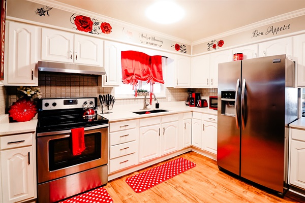 Modern Charm: A Bright and Welcoming Kitchen Accented with Vibrant Red Curtains and Mat 🍽️🔴