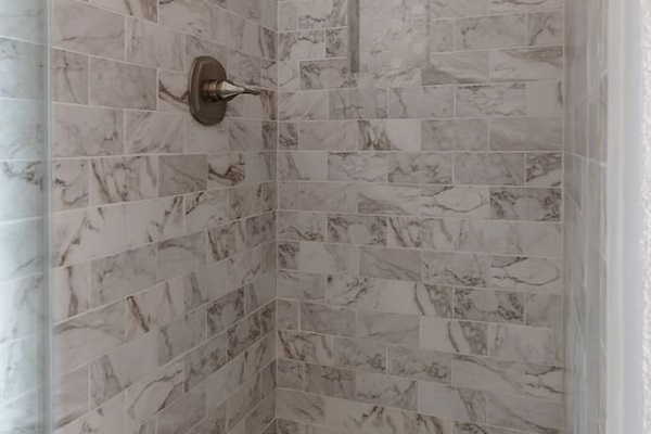 Step into this luxurious bathroom featuring a sleek sink and mirror combo, a inviting bathtub, and a spacious walk-in shower. Pamper yourself in style and comfort.