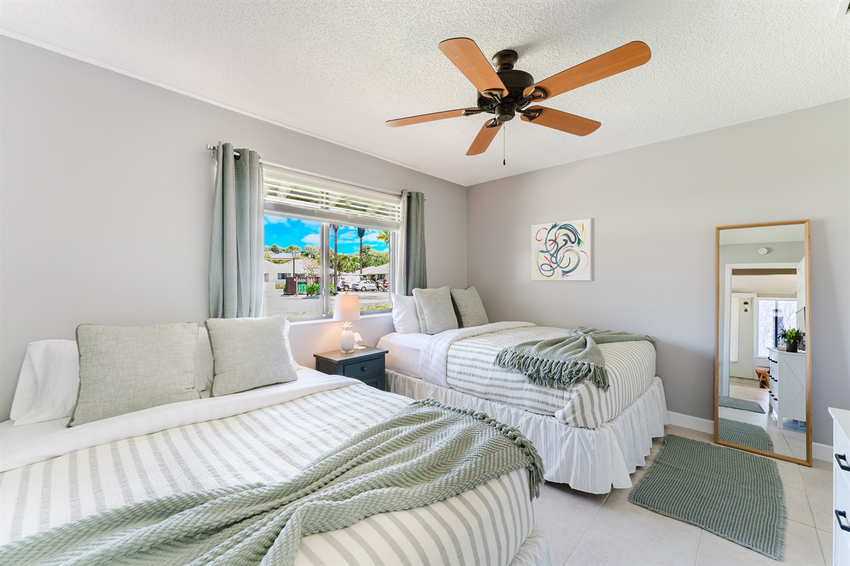 Bright guest bedroom with two queen beds, Smart TV with cable, and ample closet and dresser storage
