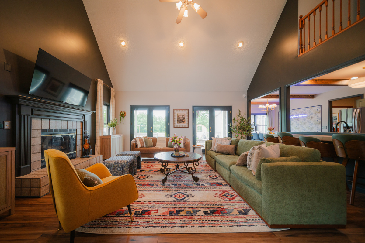 The heart of the home features vaulted ceilings, comfortable seating, a smart TV, fireplace, and stunning views of the outdoors.
