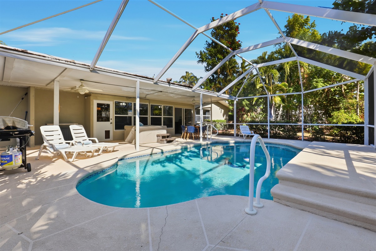 Lanai with pool, hot tub, grill, and lounge chairs.