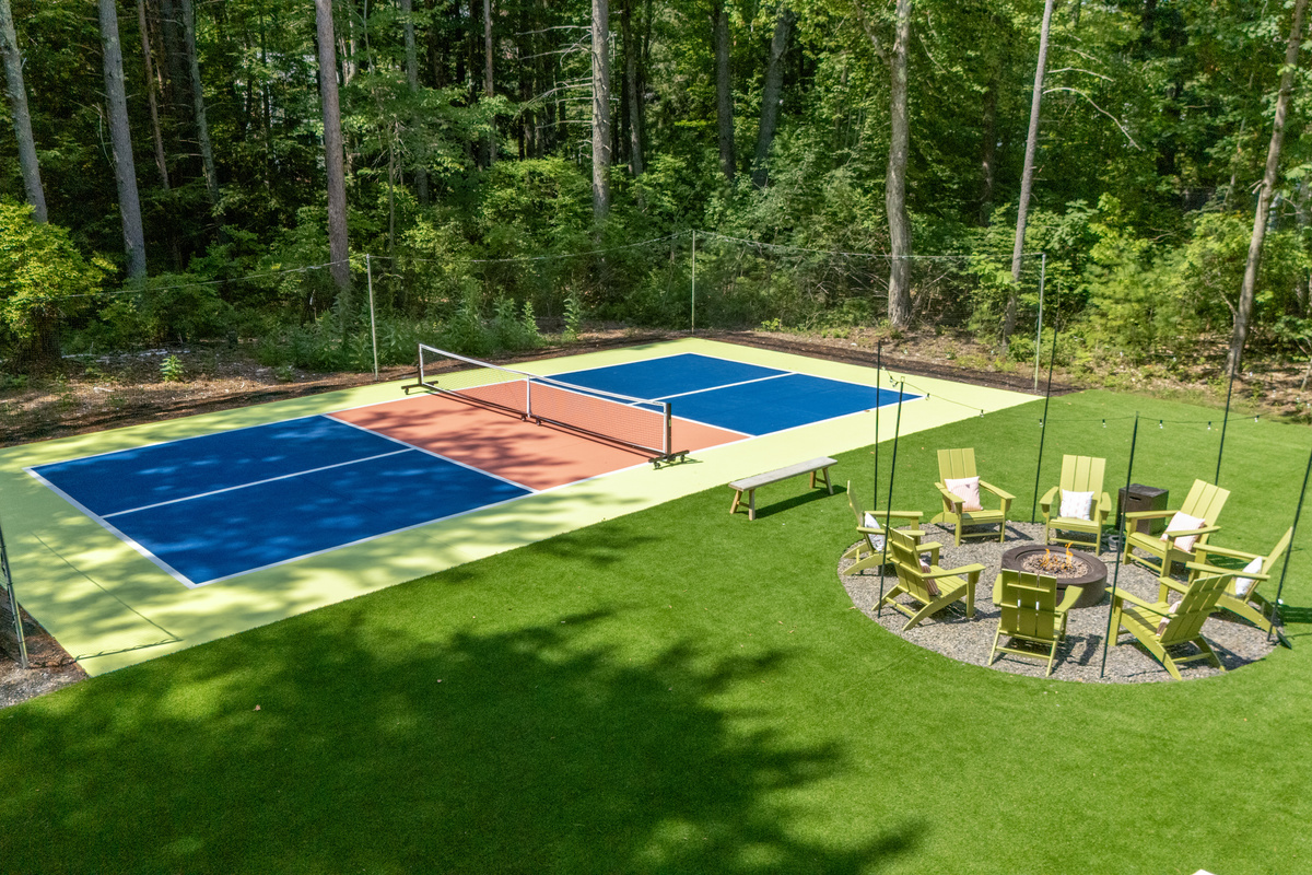 A spacious backyard featuring a Pickleball court, firepit, gatherings, and relaxed time under the open sky.