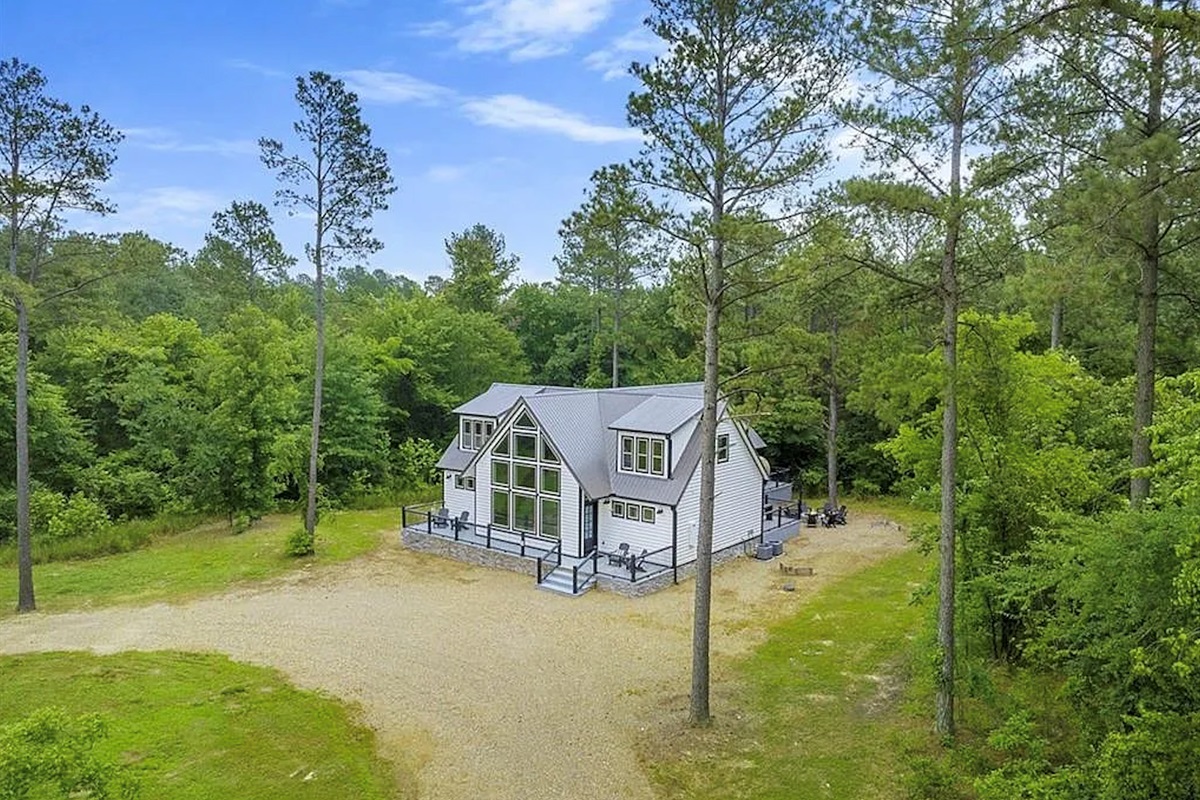 Scenic aerial view of the cabin surrounded by peaceful woodland.
