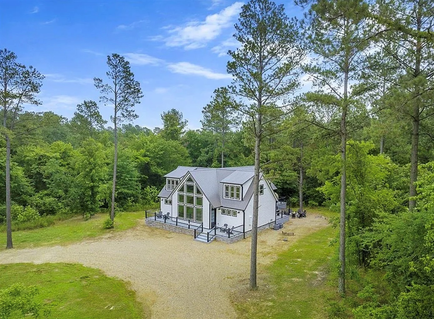 Scenic aerial view of the cabin surrounded by peaceful woodland.