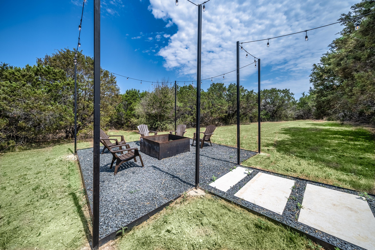 A paved walkway leads to a peaceful, tree-shaded patio nook.