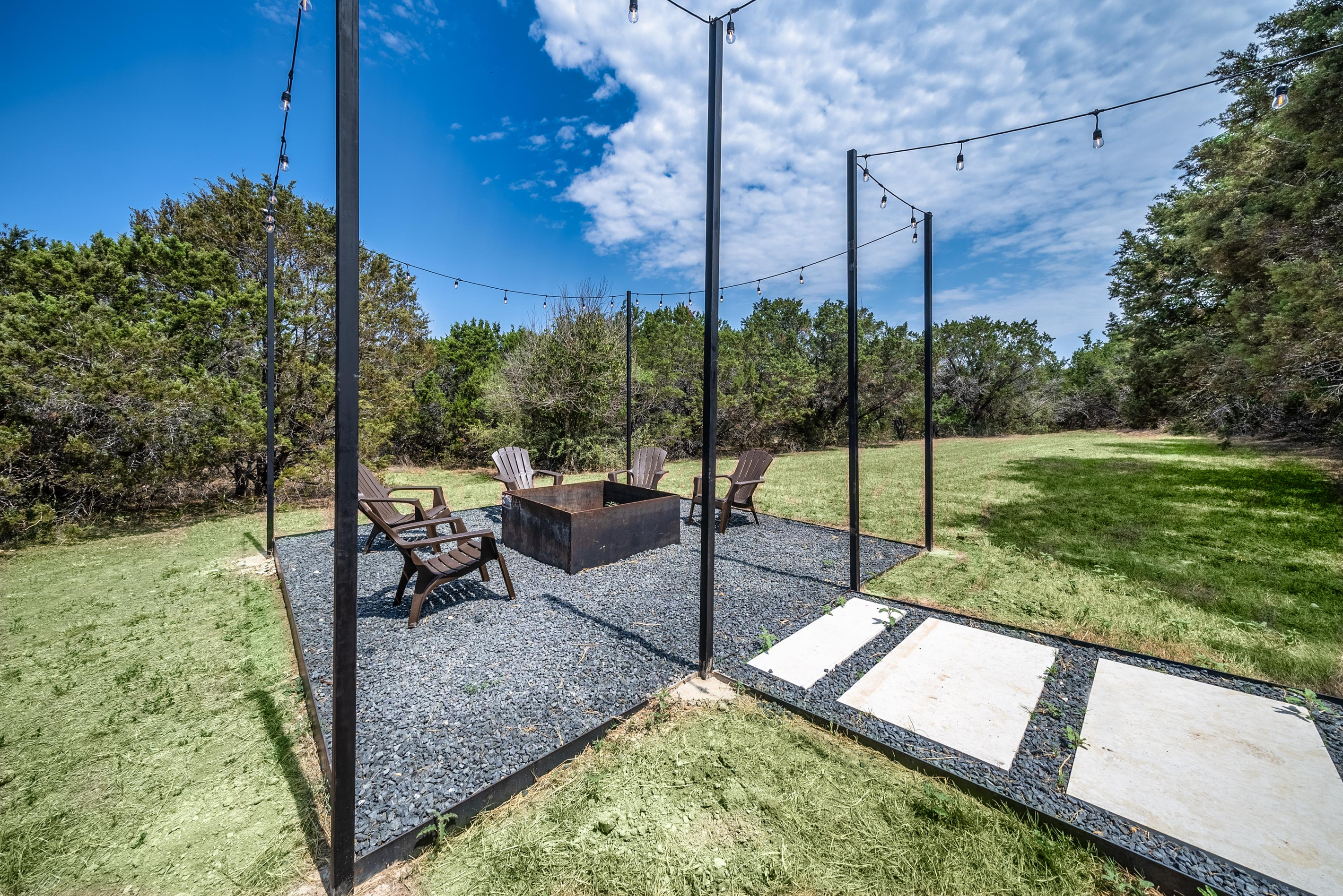A paved walkway leads to a peaceful, tree-shaded patio nook.