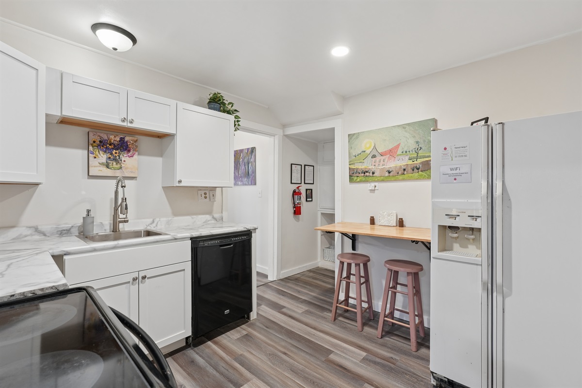 The kitchen includes a glass-top stove, dishwasher, folding wall table for two, and plenty of storage cabinets.