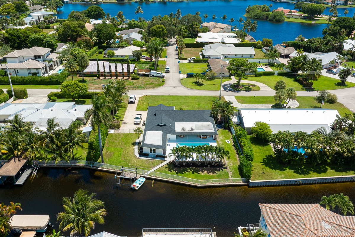 This stunning home sits along a private canal with direct access to Lake Ida, offering a true waterfront retreat. From above, you can see the sparkling pool, lush landscaping, and serene neighborhood that make this property ideal for families and groups.