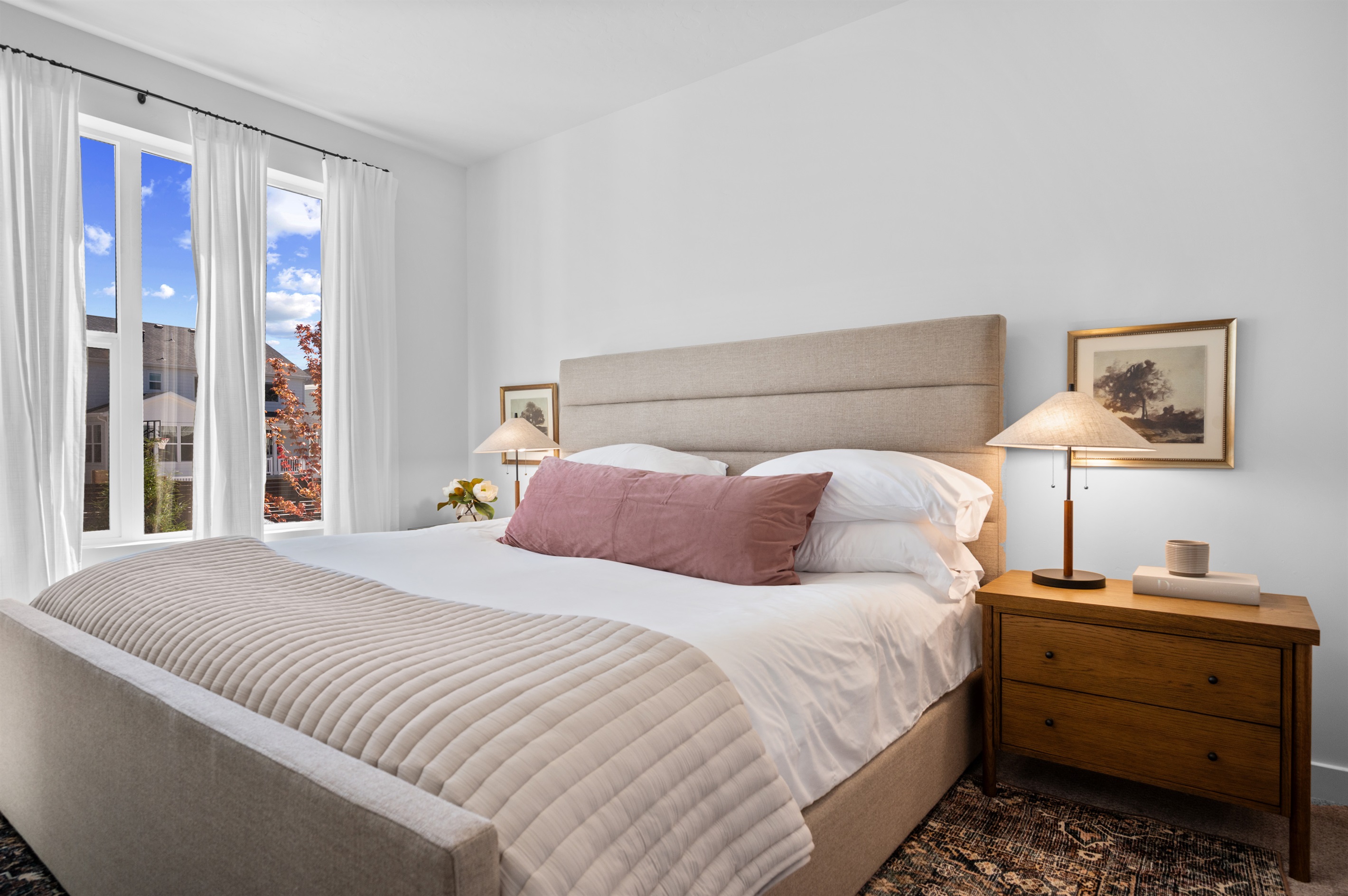 Spacious primary bedroom with a king bed, soft linens, and warm natural light.